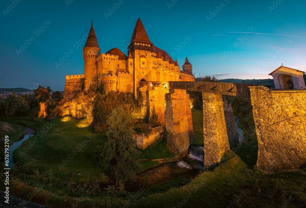 Castle with a clock tower in the background: Corvin Castle Hunedoara Romania