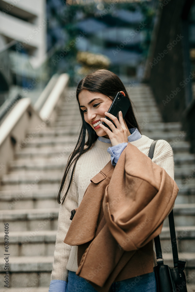 Shot of a young businesswoman using a cellphone in the city