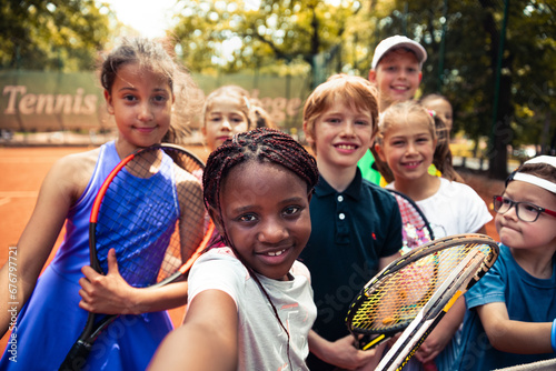 Portrait young children tennis players looking at camera taking selfie