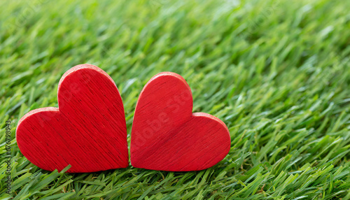 Two red wooden hearts on grass