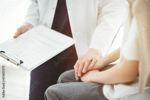 Doctor and child patient. The physician is holding clipboard and reassuring a boy. The concept of ideal health in medicine