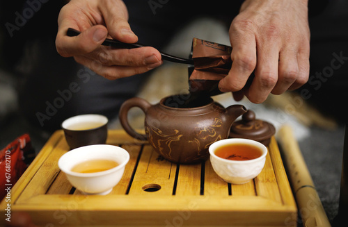 Clay teapot and several mugs of tea in a tea ceremony. Tea ceremony