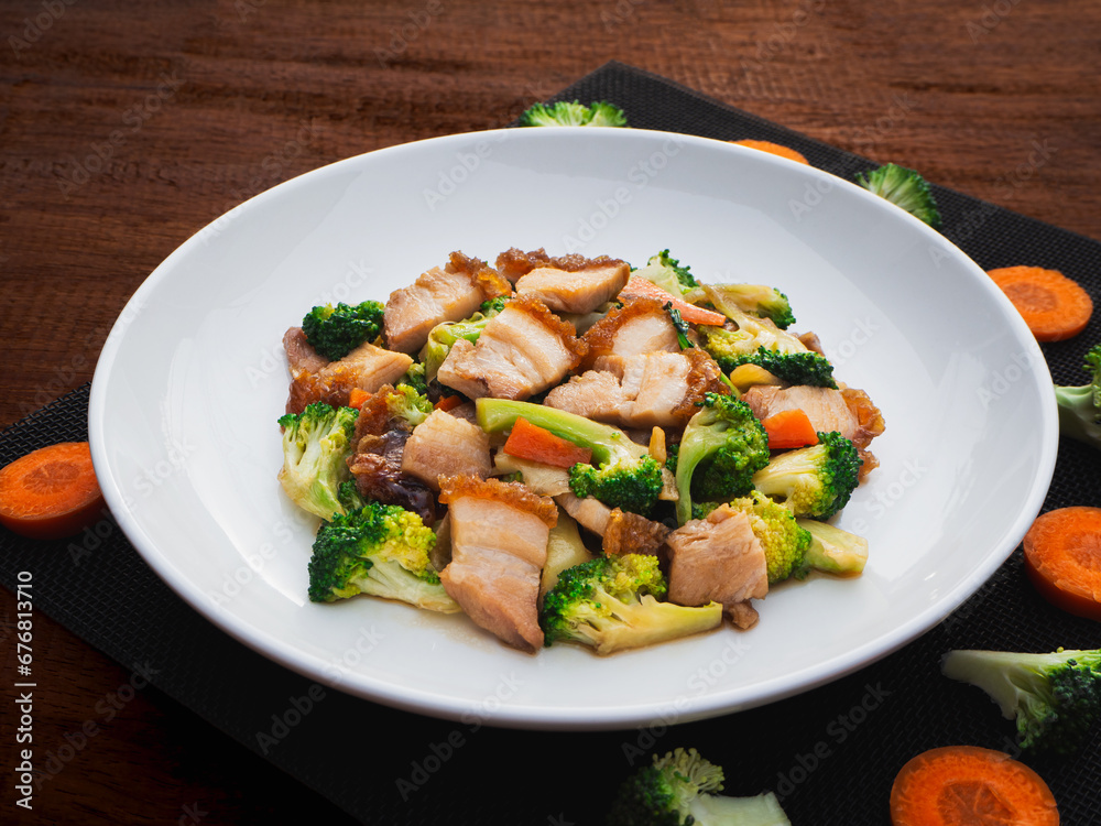 Stir fried mixed vegetables with crispy pork in plate on wooden table background. Thai Food Stir fried mixed vegetables with crispy pork in plate on wooden table background. Thai Food