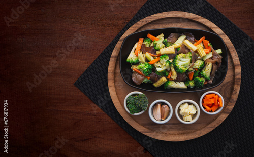 Top view of stir fried mixed vegetables in plate on wooden table background. Healthy Food