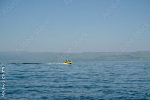 yellow speed boat sail fast on the Sea of Galilee