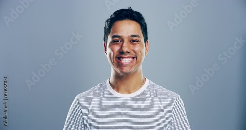 Face, smile and an indian man in trendy clothes for fashion in studio isolated on a gray background for style expression. Portrait, happy and clothing with a confident young person in casual outfit photo