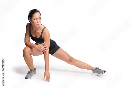 an asian woman is working out wearing the sport exercise suit with white background.