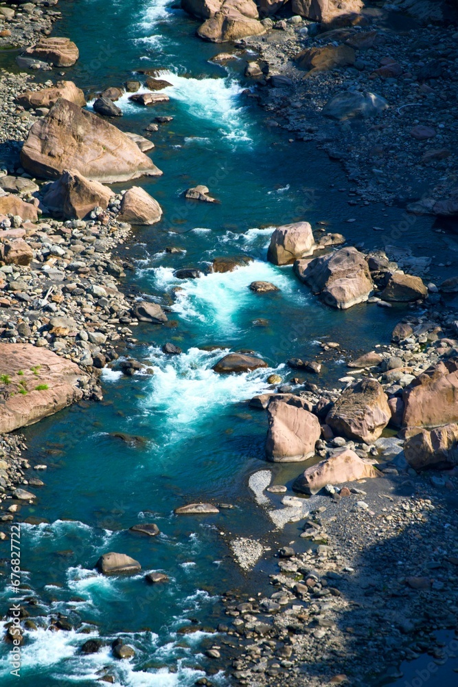 an aerial view of a river with rocks on either side