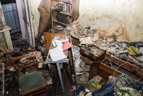 Consequences after a short circuit, burnt house interior, damaged apartment after fire, burned room, charred furniture, household items and things, garbage