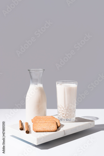 Vaso de leche y botella llena de leche. Desayuno con galletas de canela