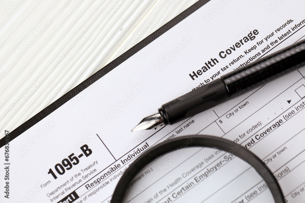 IRS Form 1095-B Health Coverage tax blank on A4 tablet lies on office table with pen and magnifying glass close up IRS Form 1095-B Health Coverage tax blank on A4 tablet lies on office table with pen and magnifying glass close up