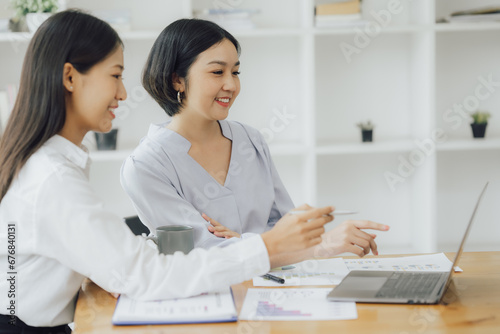 Asian Businesswoman Using laptop computer and working at office with calculator document on desk, doing planning analyzing the financial report, business plan investment, finance analysis concept.