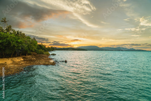 Panoramic View of Coconut Island in Thailand. Tropical Landscape with Turquoise Sea. Sunset, Coastline. Beautiful Rocky Coastline During a Colorful Sunset. Magnificent Tropical Trees Along the Shore.