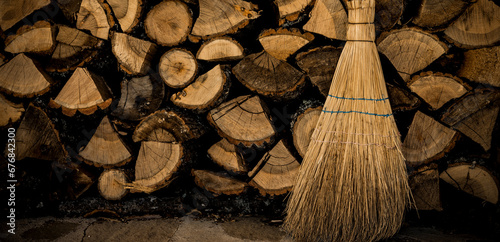 Brennholzscheite aus Eichenholz und Kehrbesen