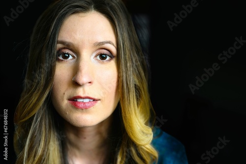 Portrait of a woman looking at the camera against a dark background