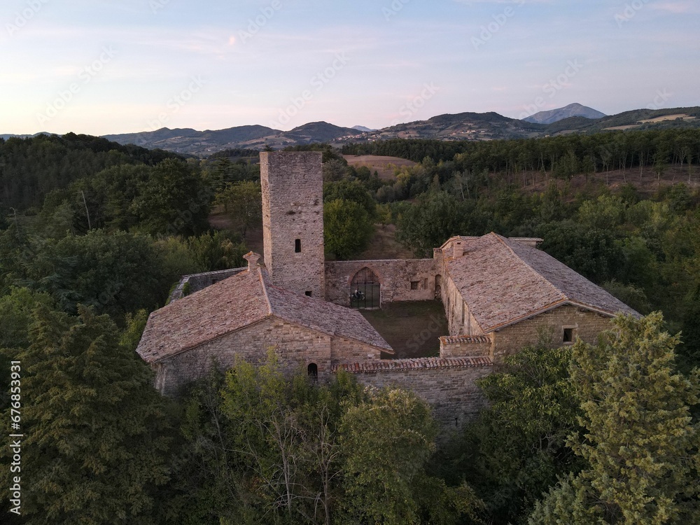 Aerial view of a beautiful old castle surrounded by lush green trees at sunset Aerial view of a beautiful old castle surrounded by lush green trees at sunset