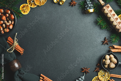 Christmas card. background with Christmas winter spices and ingredients for baking on a dark slate.