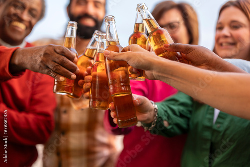 close up of friends toasting with beer in hand.