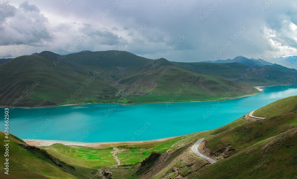 Incredible view of Yamdrok lake in Tibet with bright azure water surrounded by green hills