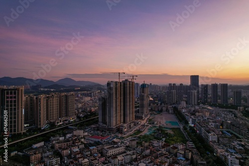 Gorgeous aerial view of a city with skyscrapers under a purple-pink sky at sunset