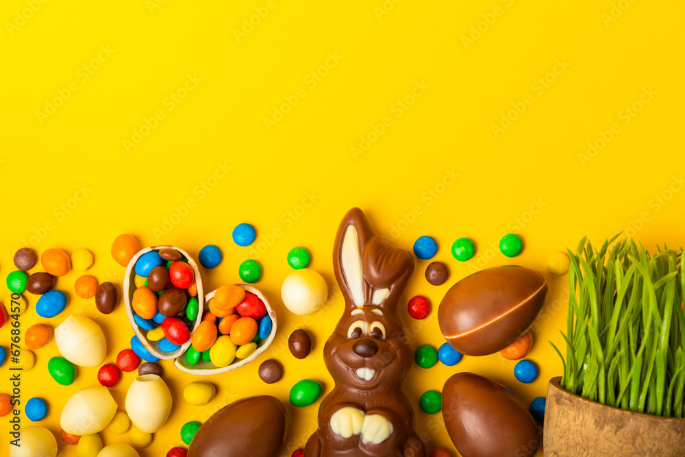 Easter chocolate bunny on a light texture table. Chocolate eggs and other sweets. Easter celebration concept. Easter sweets on the table. Place for text. copy space.