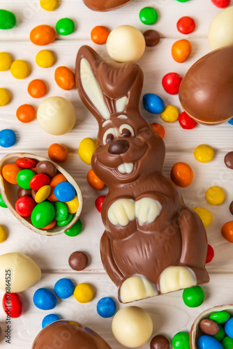 Easter chocolate bunny on a light texture table. Chocolate eggs and other sweets. Easter celebration concept. Easter sweets on the table. Place for text. copy space.