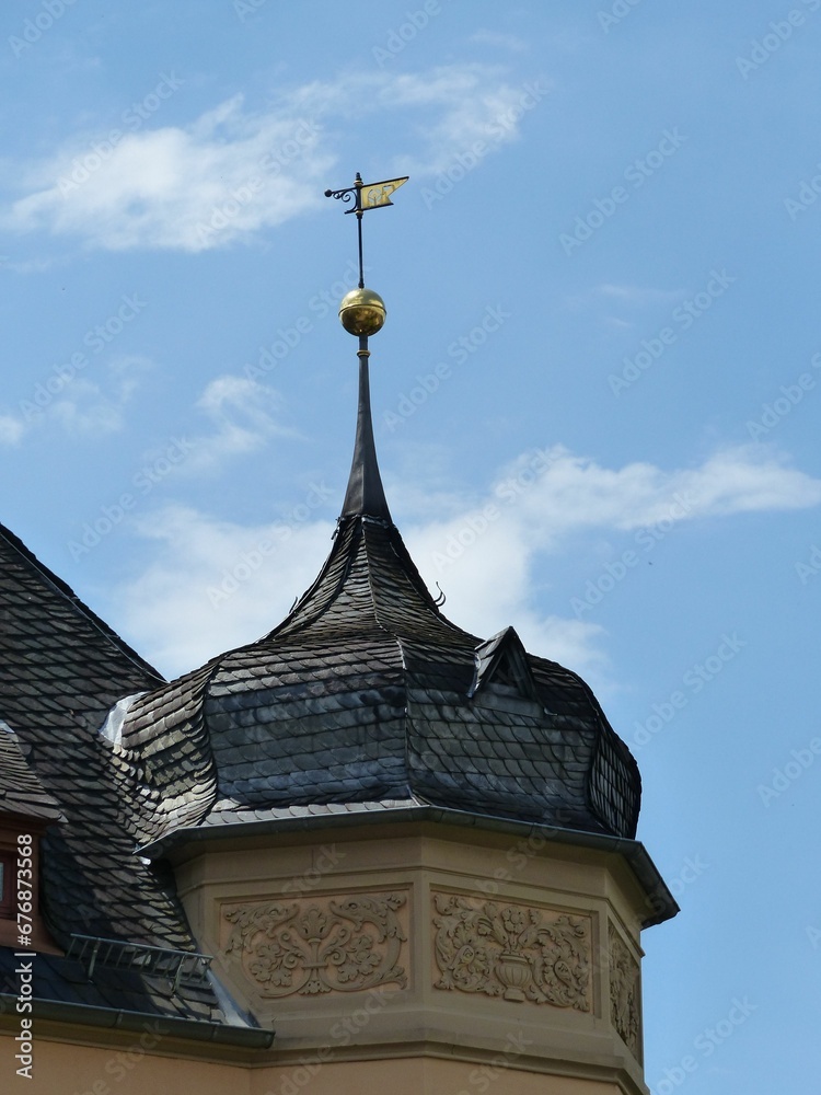 Vertical shot of old historic oriel tower against blue cloudy sky in Germany