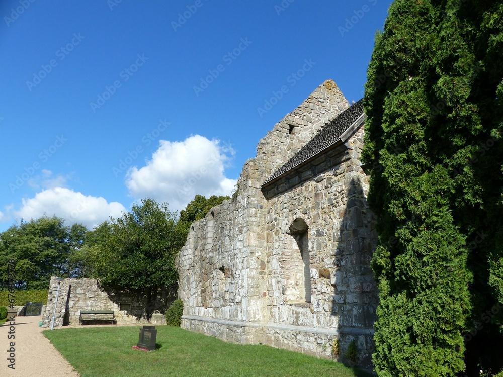 Of an old stone building on Bornholm Island surrounded by vegetation and meadow Of an old stone building on Bornholm Island surrounded by vegetation and meadow