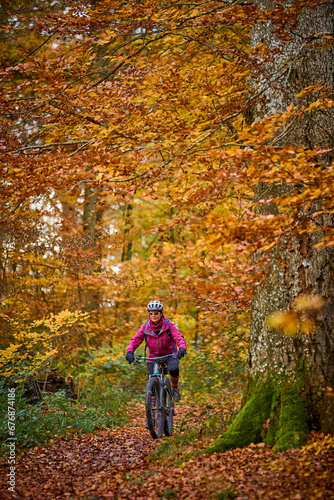 nice senior woman riding her electric mountainbike on the autumnal forest trails near Stuttgart,Baden-Wuerttemberg, Germany © Uwe