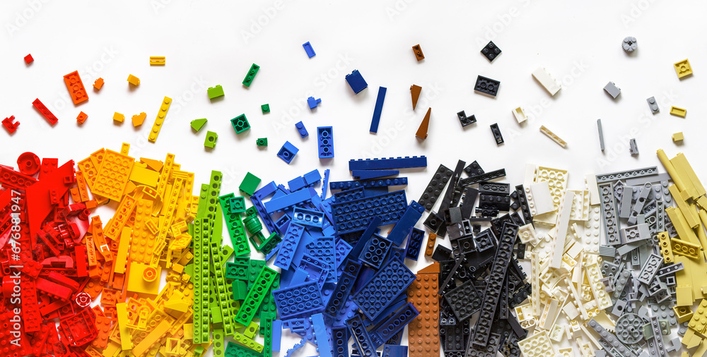 Fototapeta premium Colorful rainbow plastic toy bricks blocks on white. Lego blocks. Education concept. Novosibirsk, Russia - October 26, 2023.