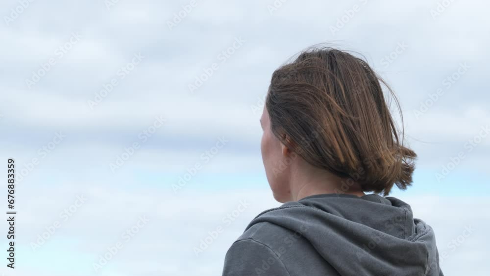 Rear view of adult female person looking into distance on windy autumn day Rear view of adult female person looking into distance on windy autumn day