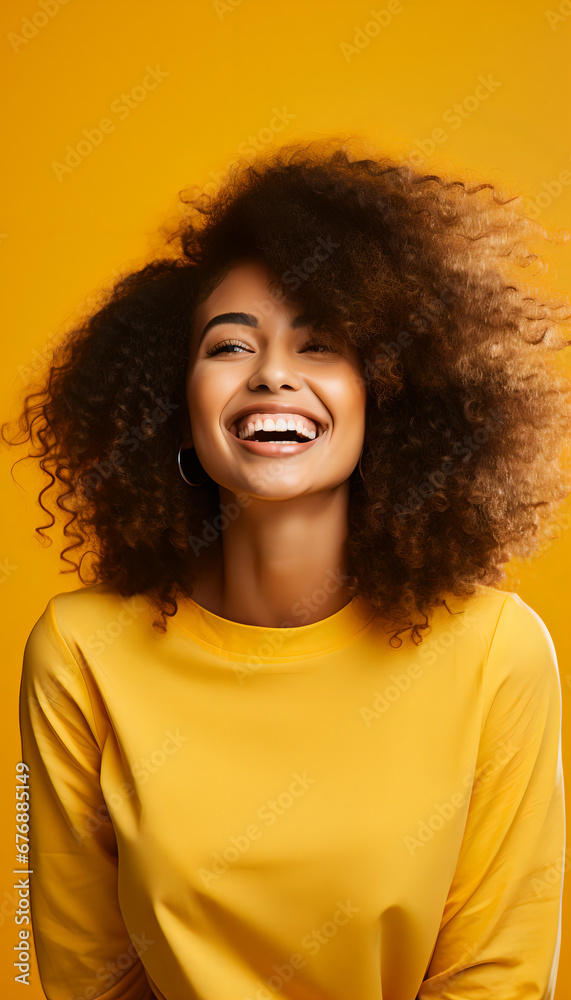 Portrait of a woman with afro hair smiling on yellow background. Portrait of a woman with afro hair smiling on yellow background.