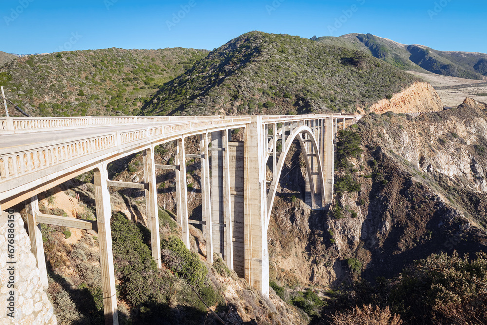 Bixby Creek Bridge and coastal mountains of the Pacific northern California landscape in summer.
