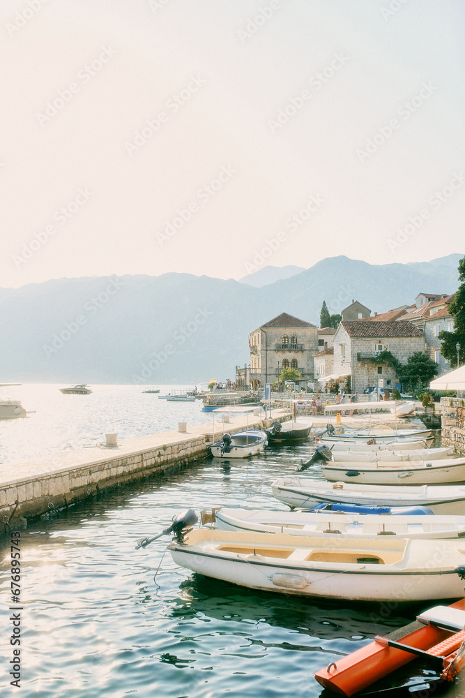 Fishing boats are moored in a row between the pier and the shore of Perast. Montenegro