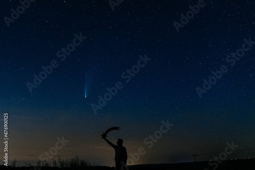 a man holding up a bird in the sky at night