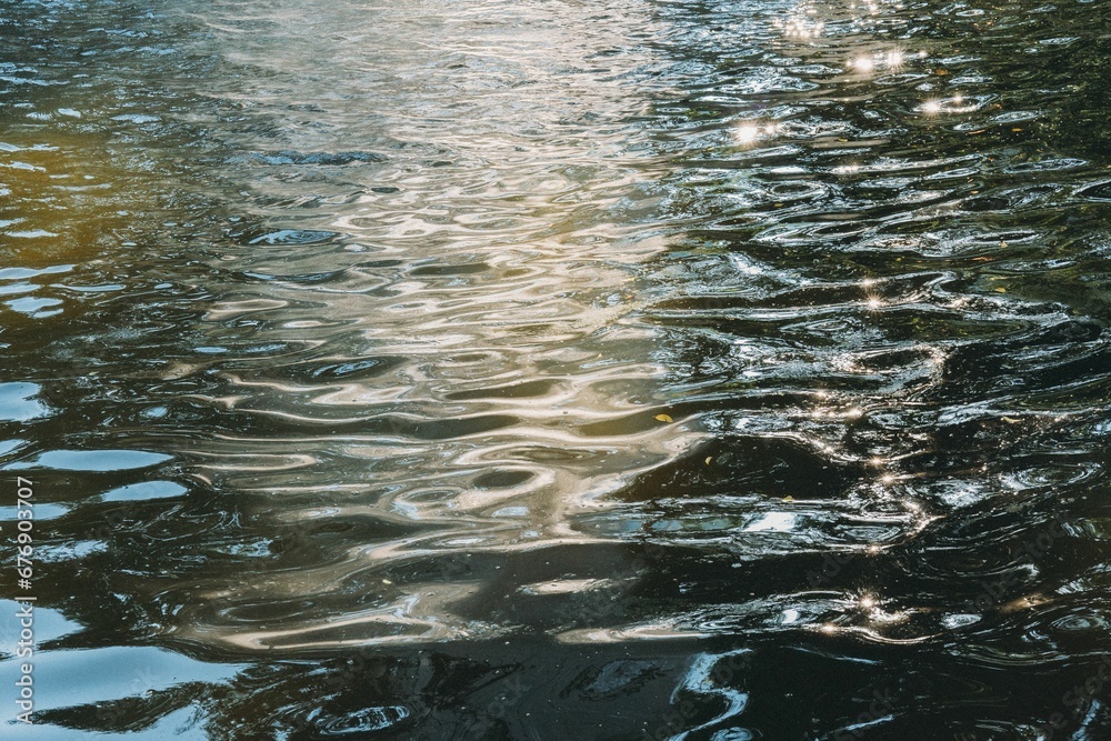 Surface of water with the reflection of sun rays.