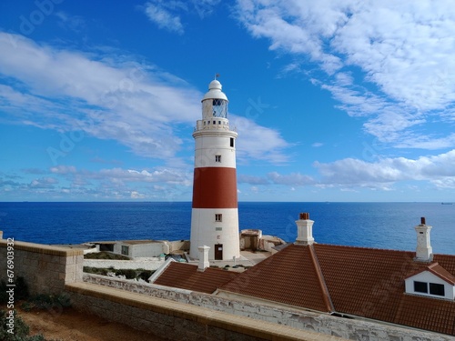 Europa Point Lighthouse with the sea and a cloudy blue sky in the background in Gibraltar