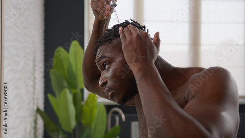 Принти на полотні African American man applying argan oil serum on hair roots dreadlocks healthy m