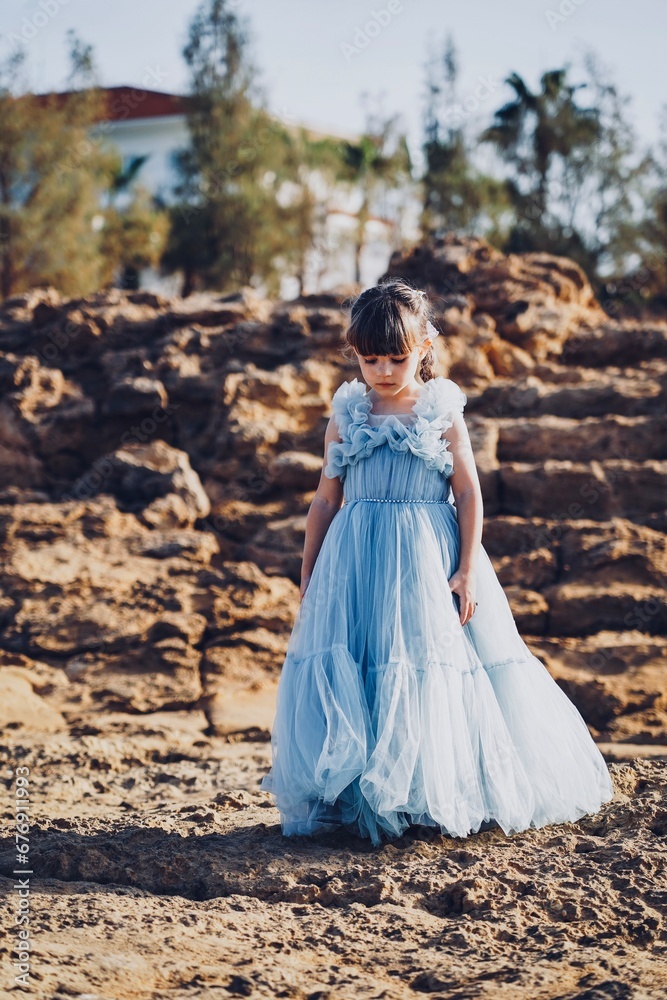 child in a blue dress on the beach in cyprus child in a blue dress on the beach in cyprus