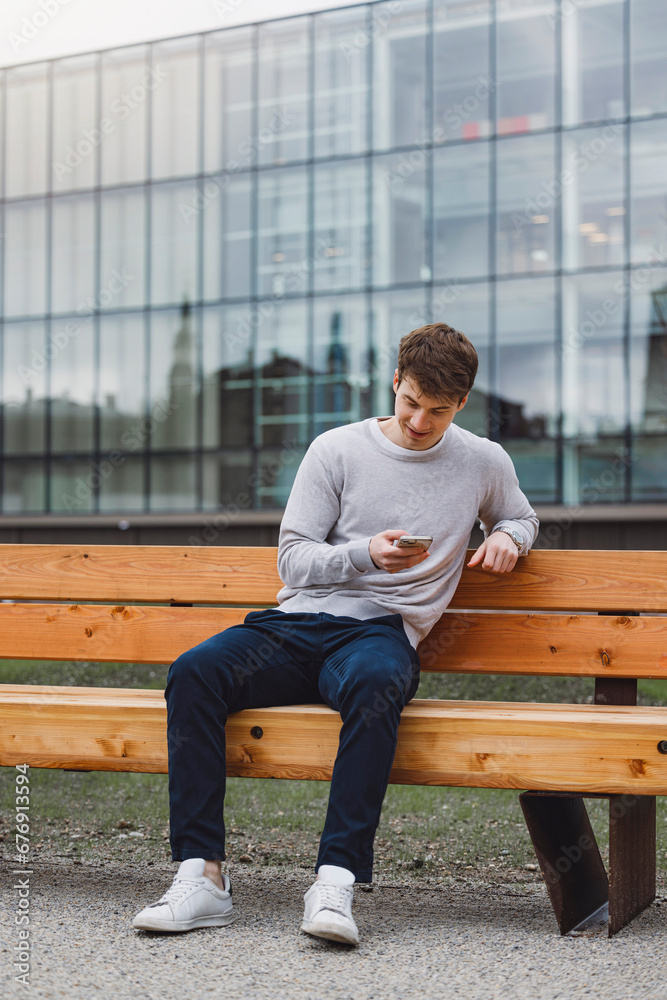 Young adult student using smart phone while going to school campus. Connected with friends everywhere, checking online bank, posting stories. Young adult student using smart phone while going to school campus. Connected with friends everywhere, checking online bank, posting stories.