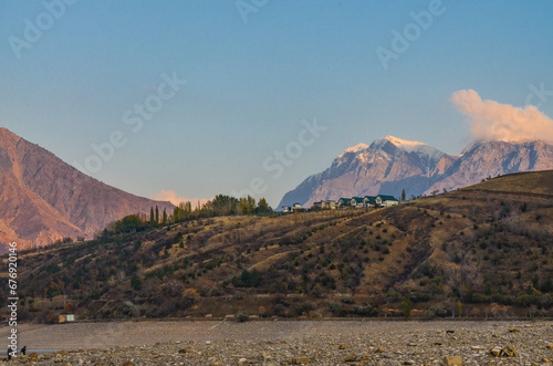 scenic view of snow covered peaks of Chatkal ridge from Charvak reservoir (Yusufhona, Tashkent region, Uzbekistan) photo