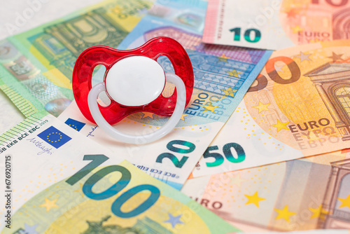 Childfree, Contraception and Birth Control Concept: Baby Pacifier on the Euro Banknotes. Having Children is Expensive and Unprofitable