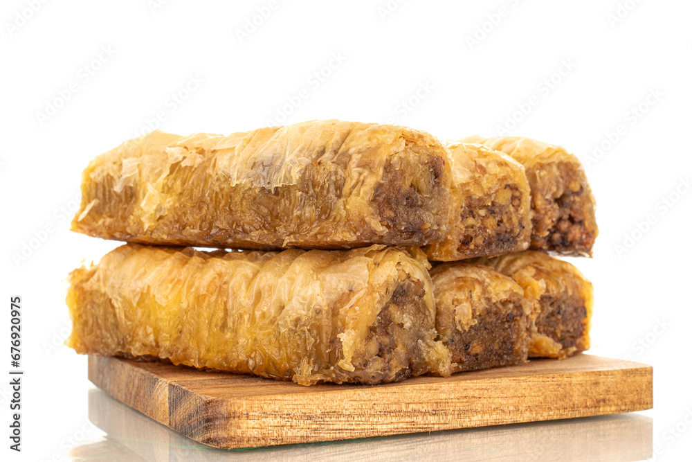 Several pieces of sweet baklava on a wooden kitchen board, macro, isolated on white background. Several pieces of sweet baklava on a wooden kitchen board, macro, isolated on white background.