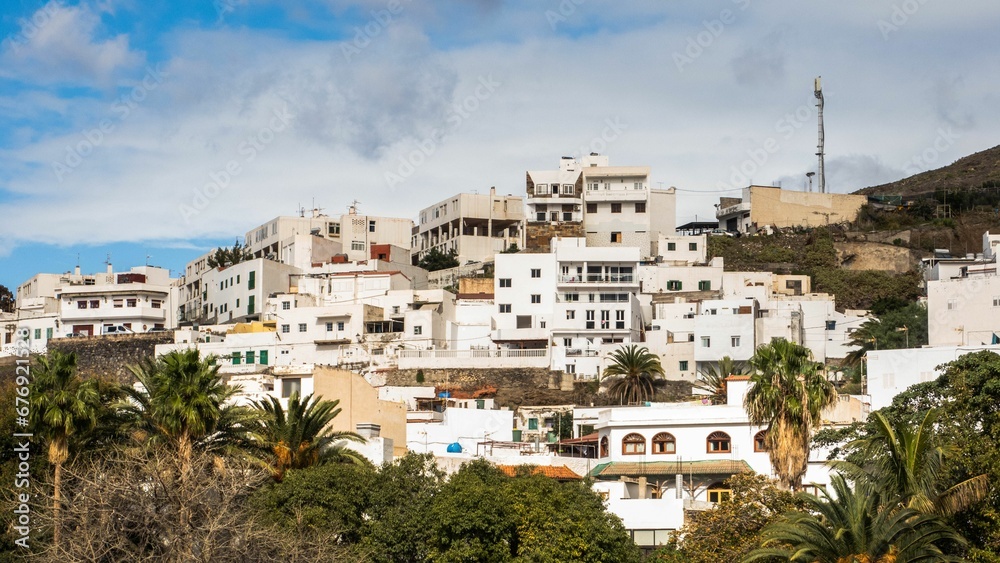 Scenic shot of a hill with a cluster of buildings atop its peak - Ageate in Spain the gran canaries