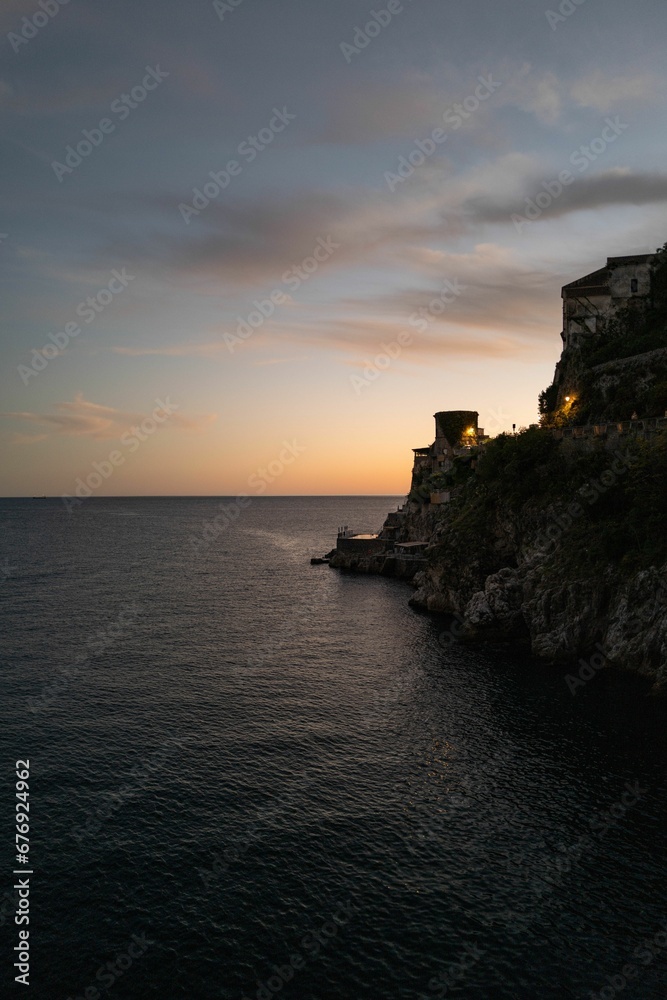 Vertical shot of a seaside castle at sunset on the Amalfi coast, Italy.