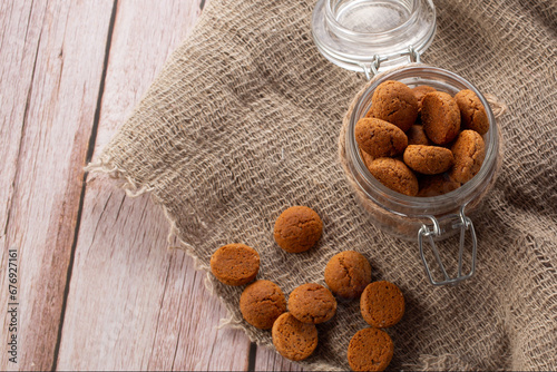 Pepernoten cookies in glass jar on sackcloth. Traditional sweets for St. Nicholas Day photo