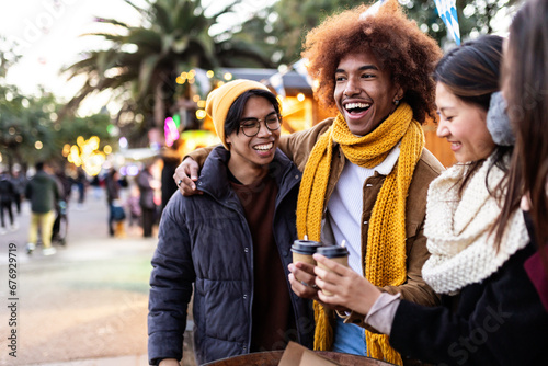 Happy young diverse friends enjoying winter holidays. Millennial people having fun during christmas trip in european city. photo