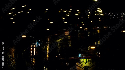 Cars are driving fast on the night road in the rain. Time lapse. Cars headlights and night city lights are reflected on the wet road. Beautiful view cars driving on the highway. 4k Video footage for n