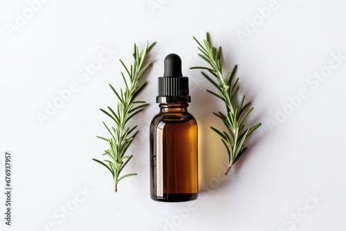 A bottle of essential oil with a sprig of rosemary. On white background.