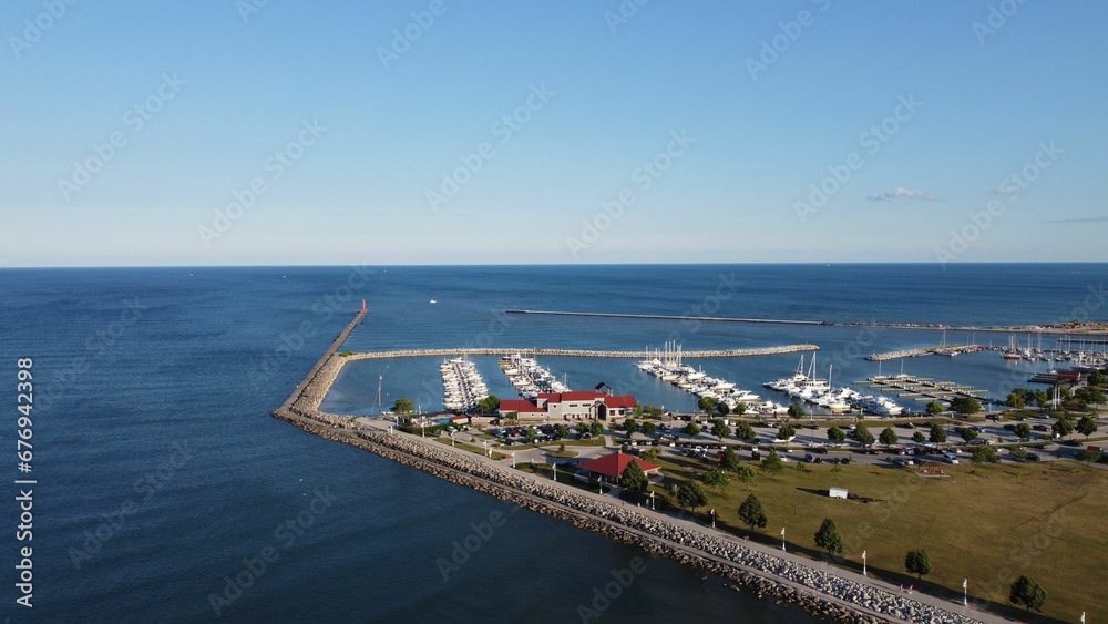 Aerial shot of the sea with piers and boats in the harbor under the clear sky